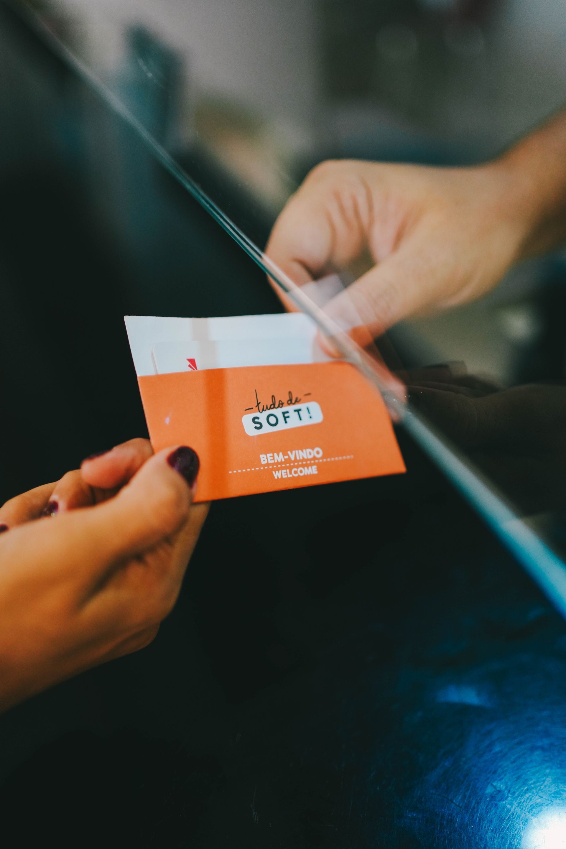 Mãos passando um pacote laranja com a etiqueta 