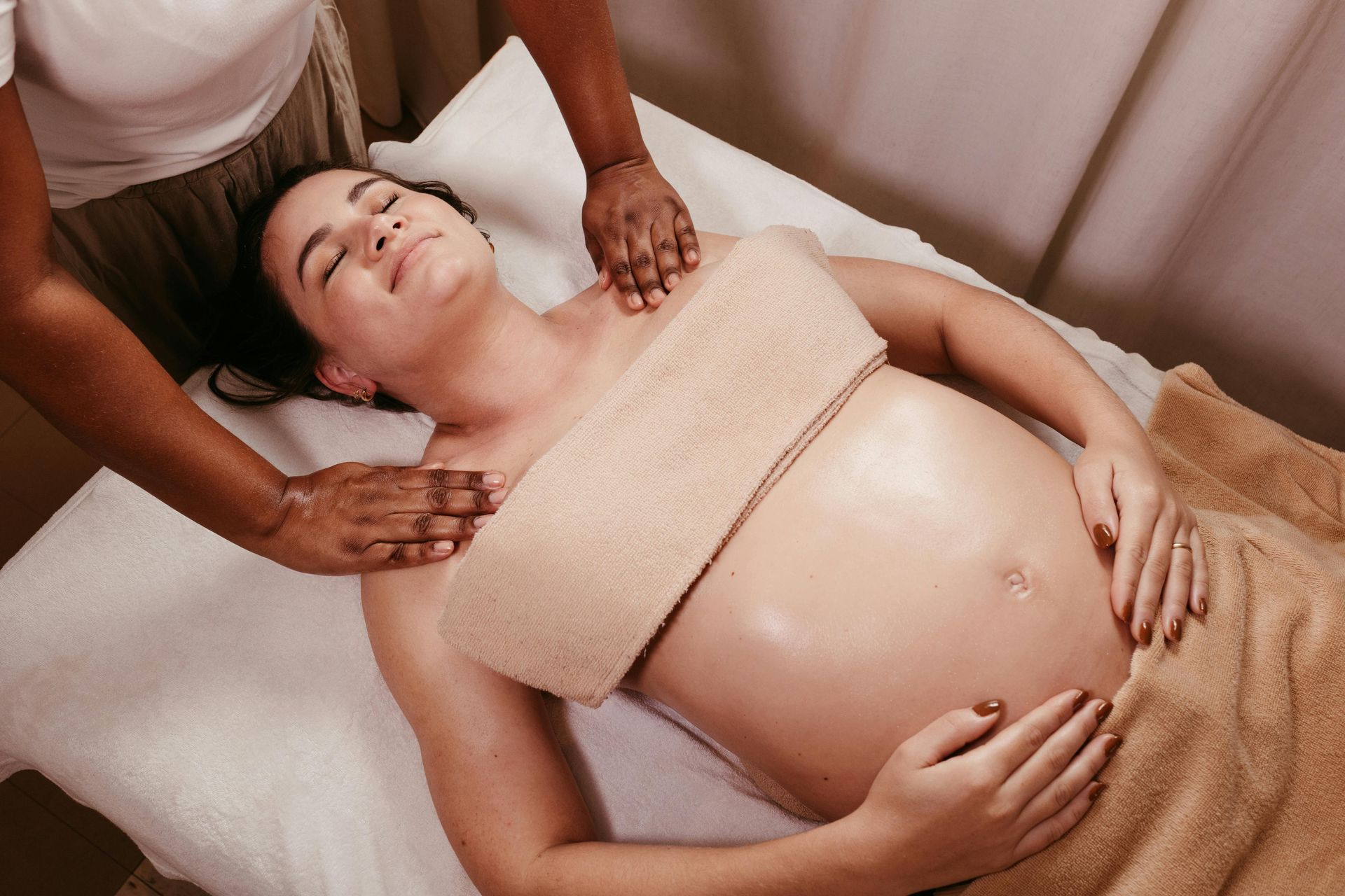 A pregnant woman is getting a massage at a spa.