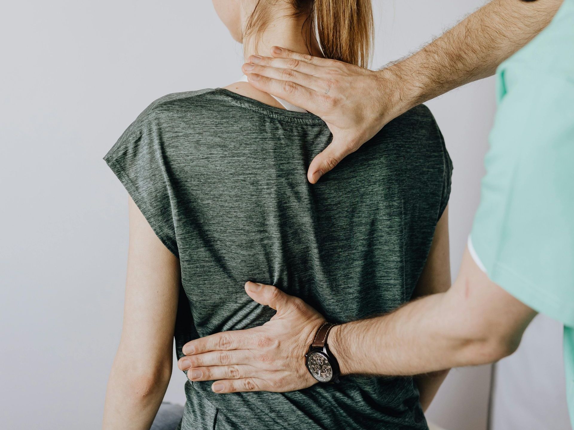 A man is giving a woman a massage on her back.