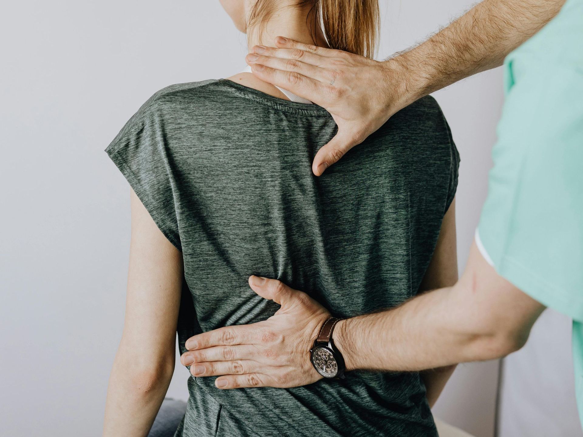 A woman is getting a neck massage from a man.