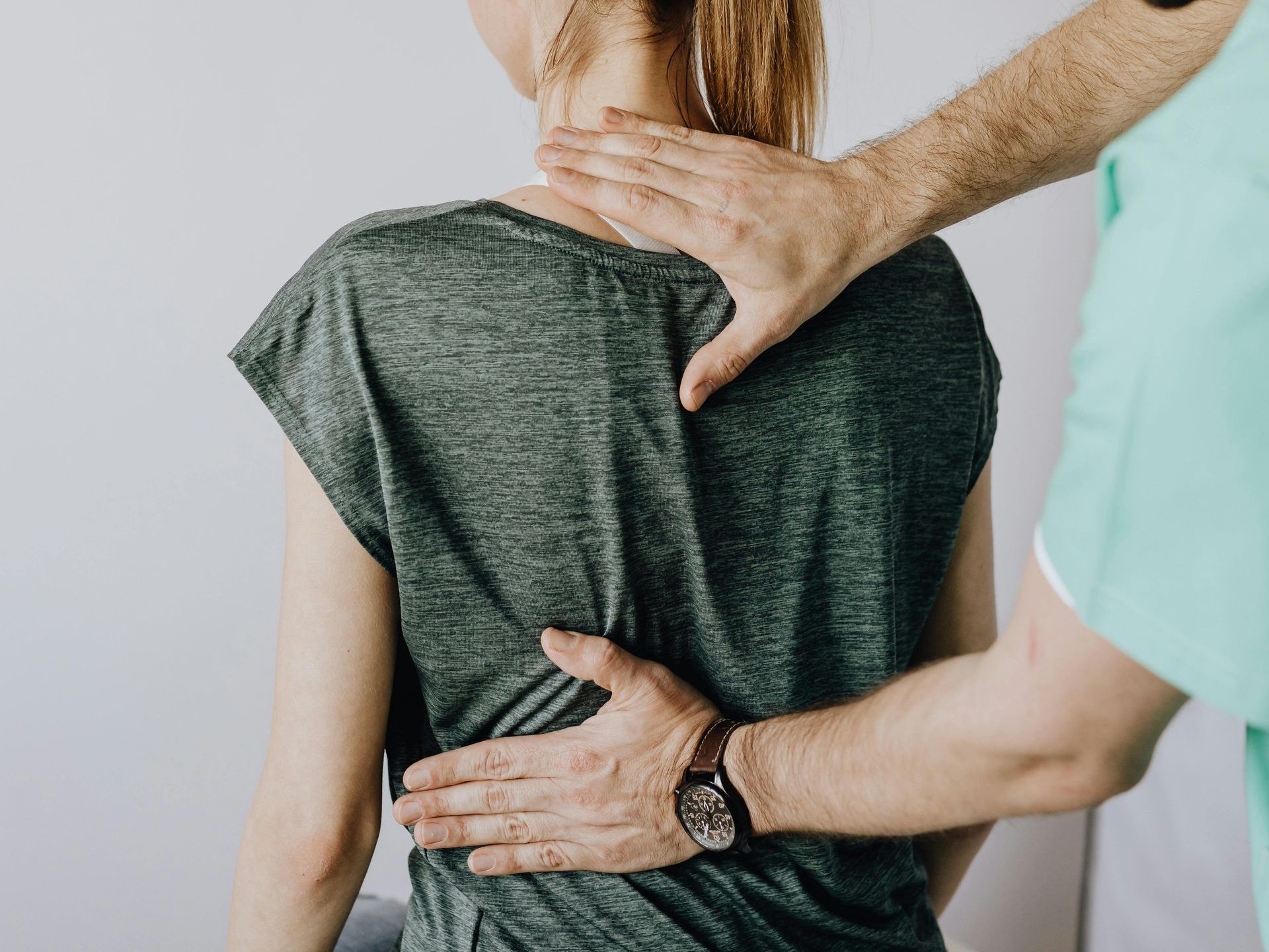 A man is giving a woman a massage on her back.