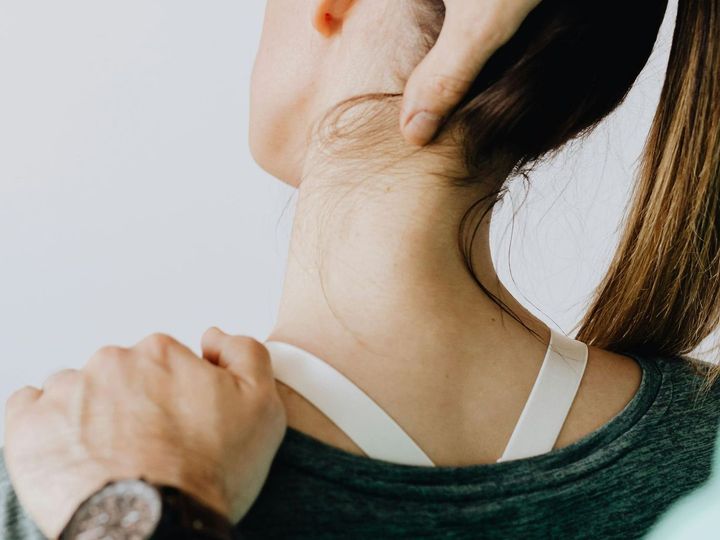 A woman is getting a neck massage from a man.