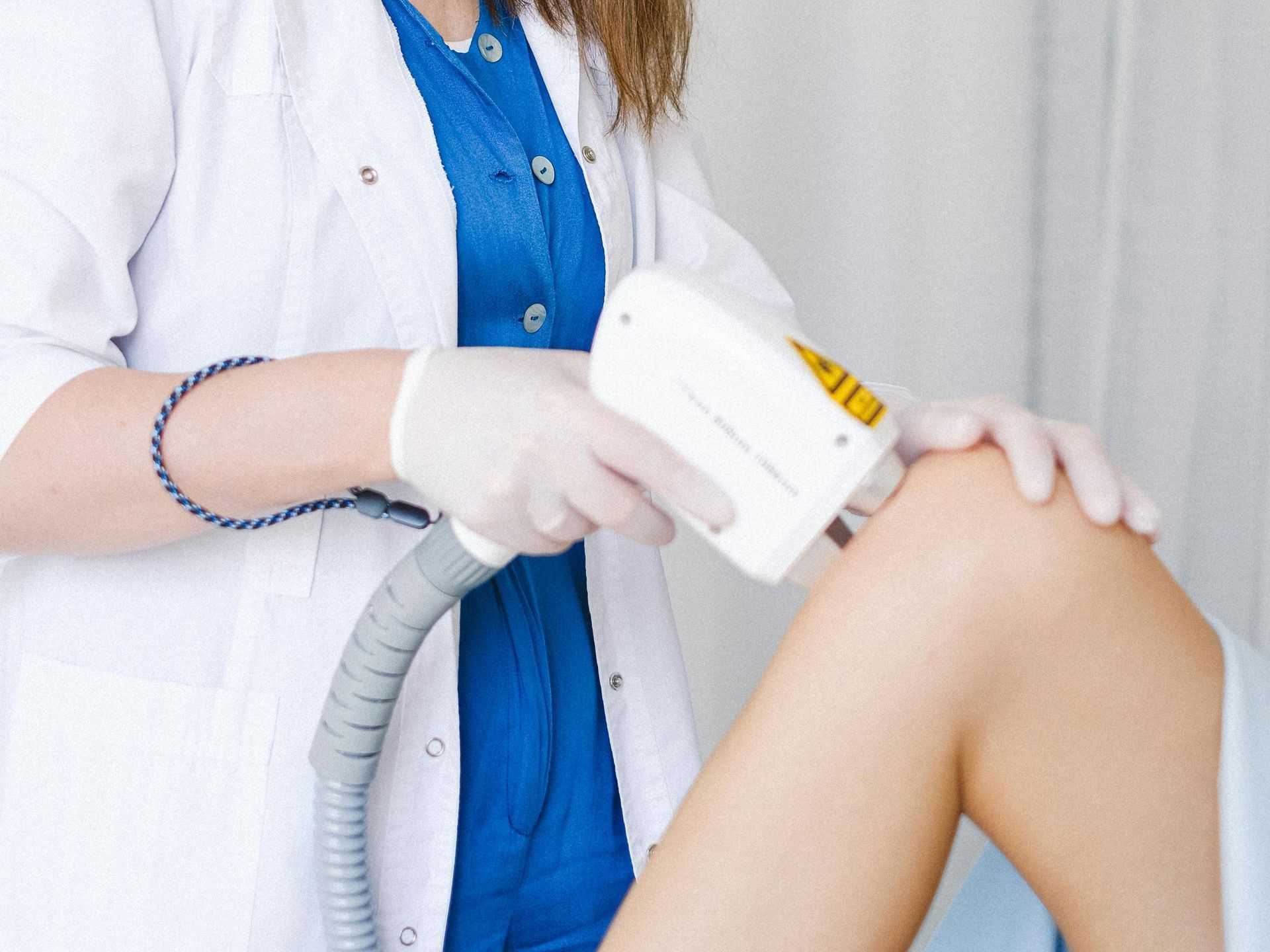 A woman is getting a laser hair removal treatment on her leg.