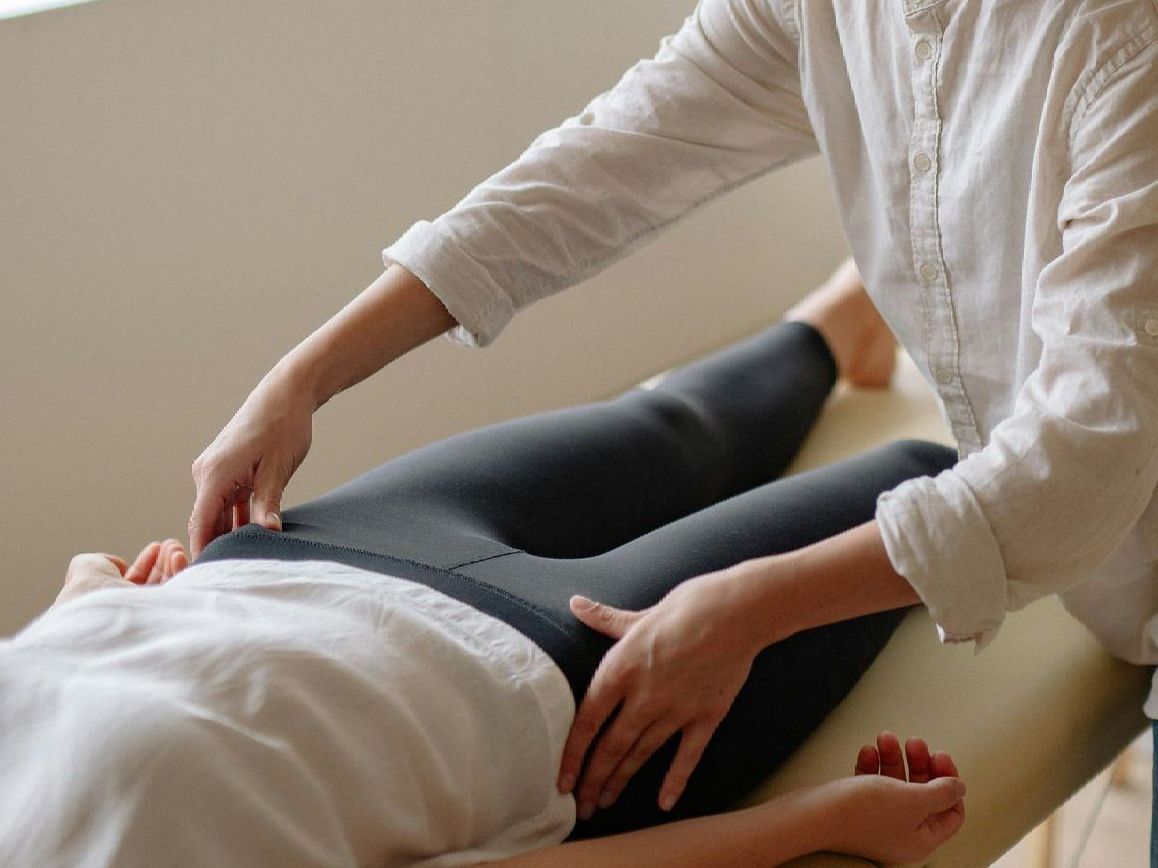 A woman is giving a massage to a woman laying on a table.