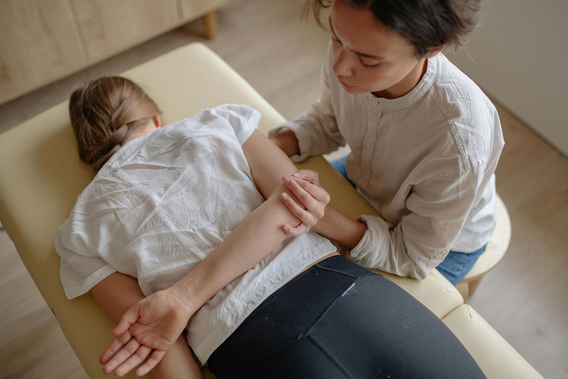 A woman is giving a child a massage on a table.