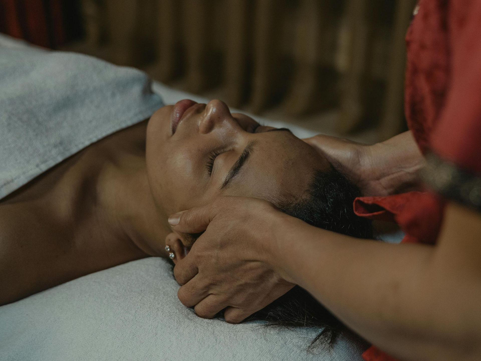 A woman is getting a head massage at a spa.