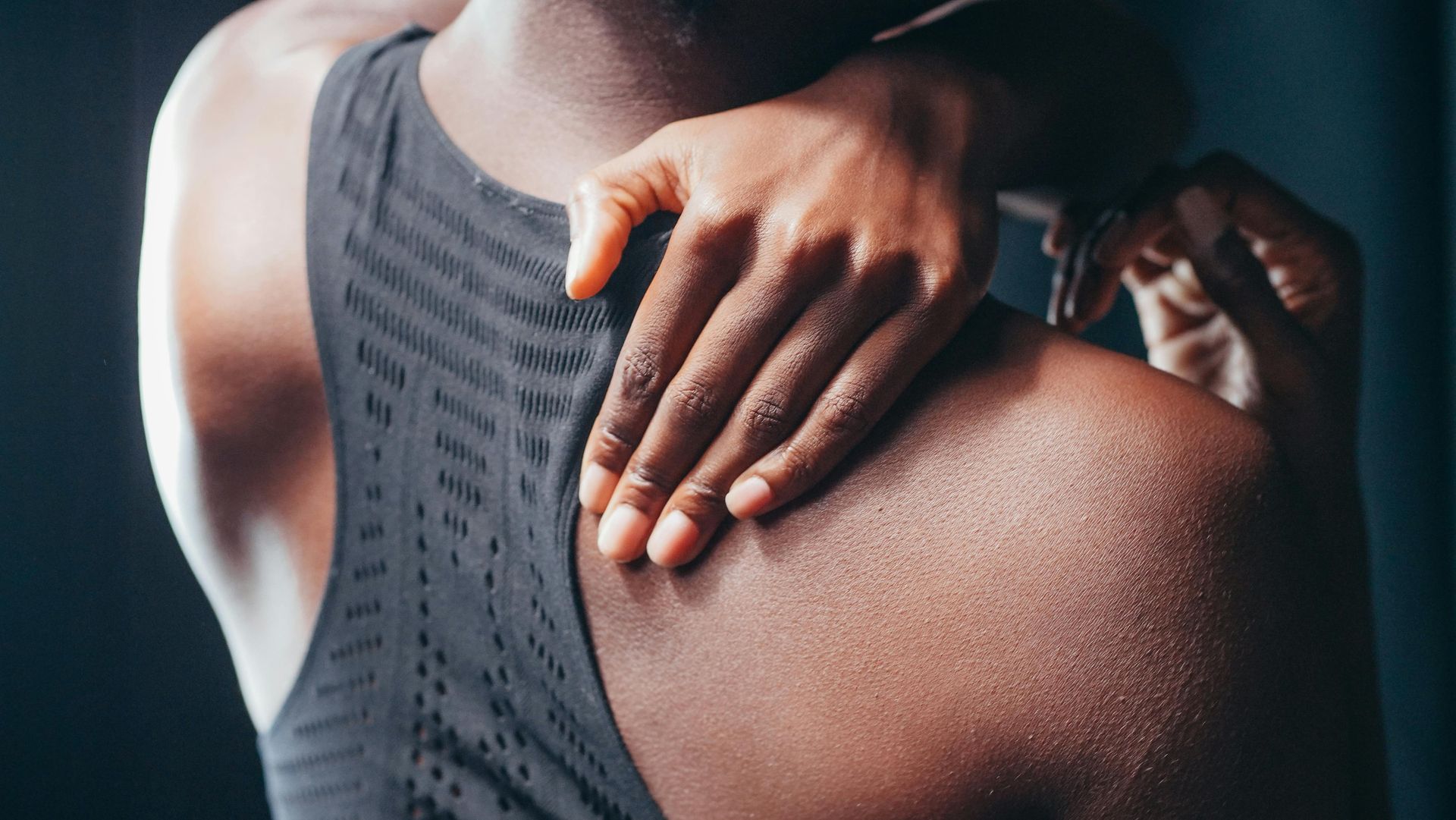 A man is holding his shoulder in pain.