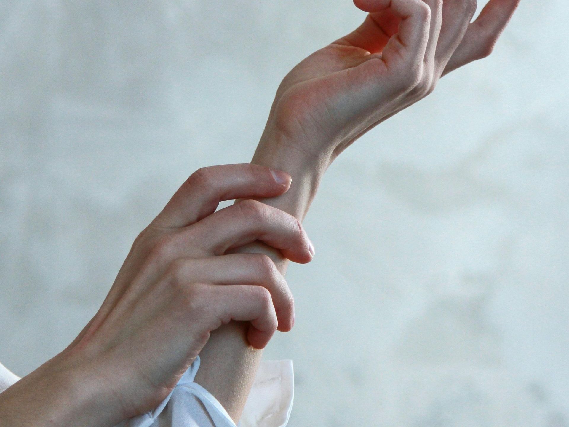 woman's hand holding her own wrist