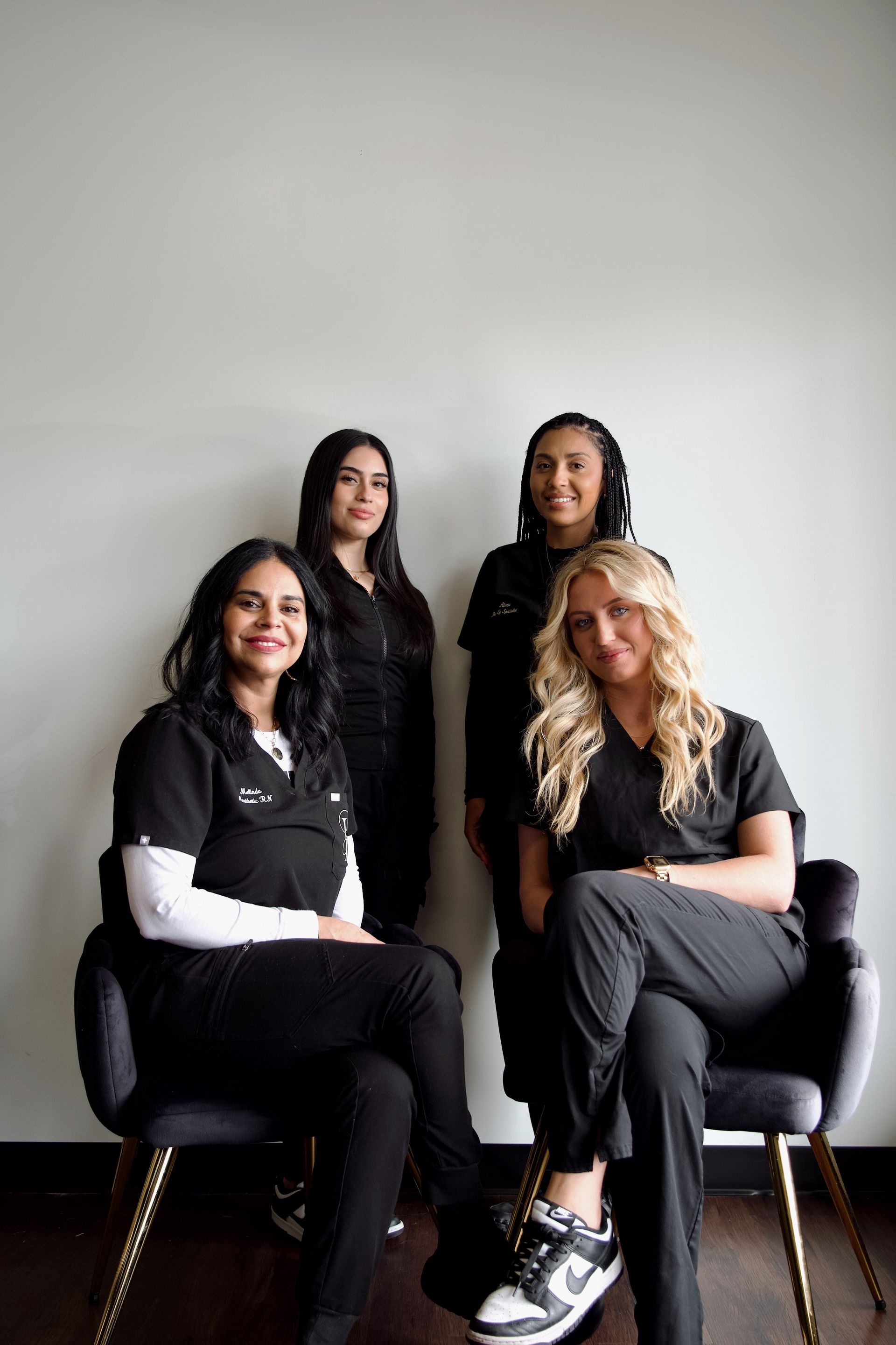 A group of women are posing for a picture while sitting in chairs.