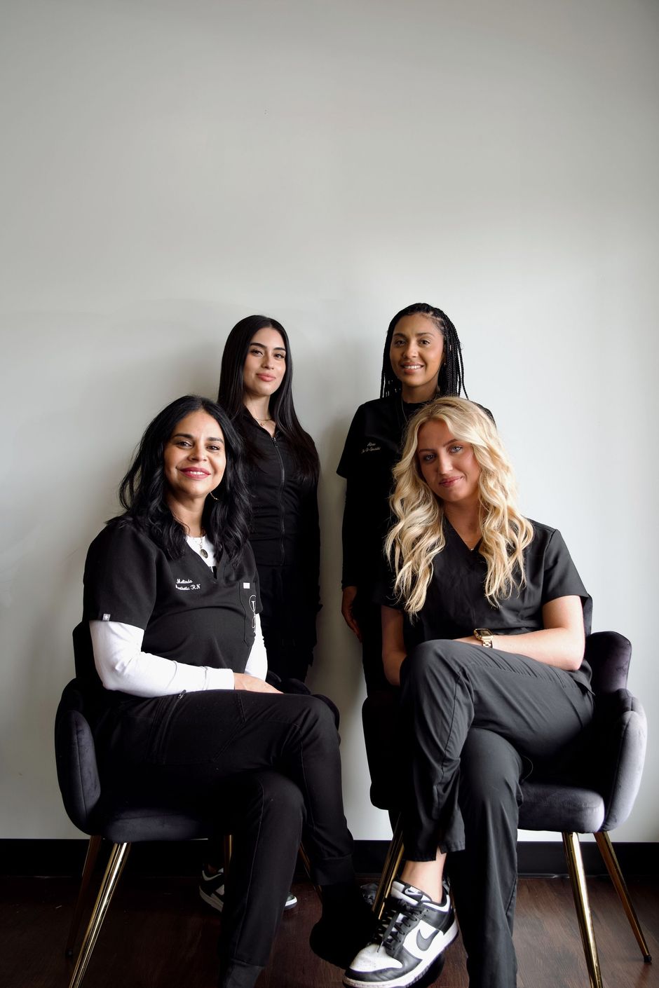A group of women are posing for a picture while sitting in chairs.