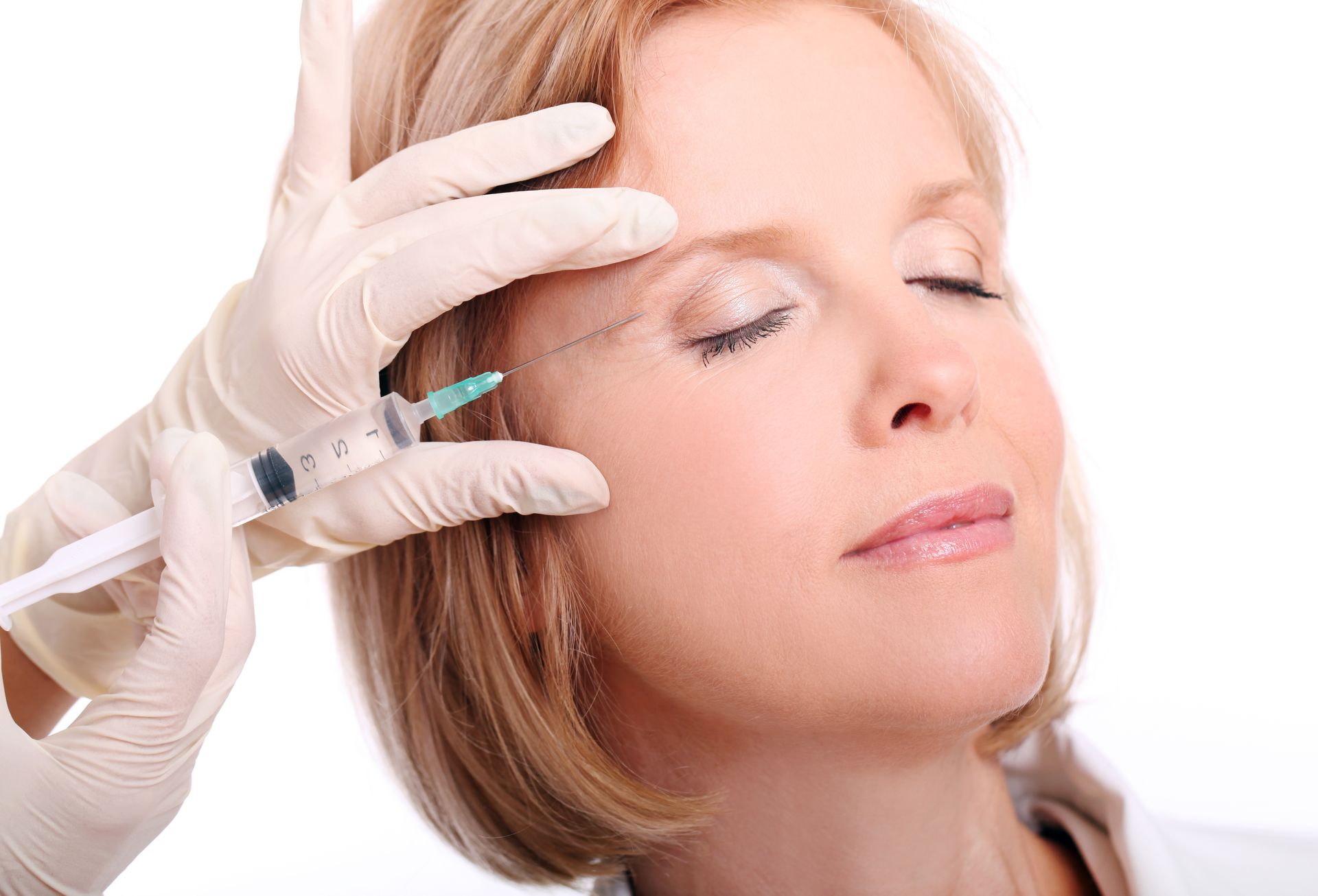 A woman is getting a botox injection in her forehead.