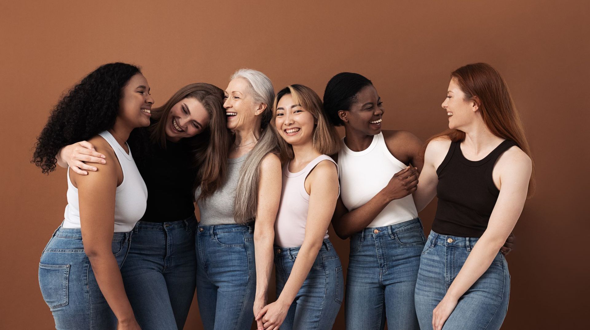 A group of women are standing next to each other and laughing.