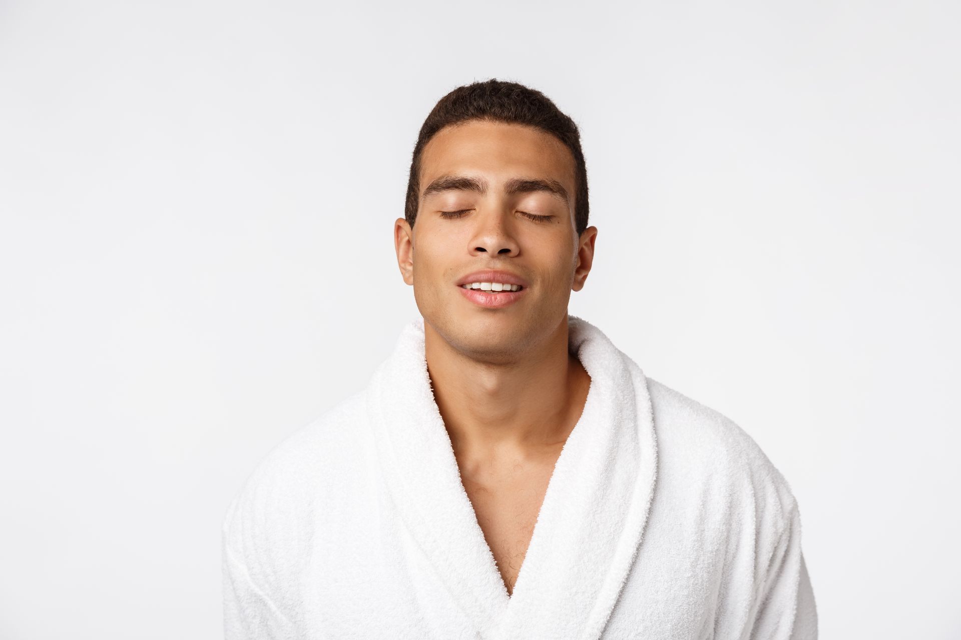 A man in a white robe with his eyes closed.