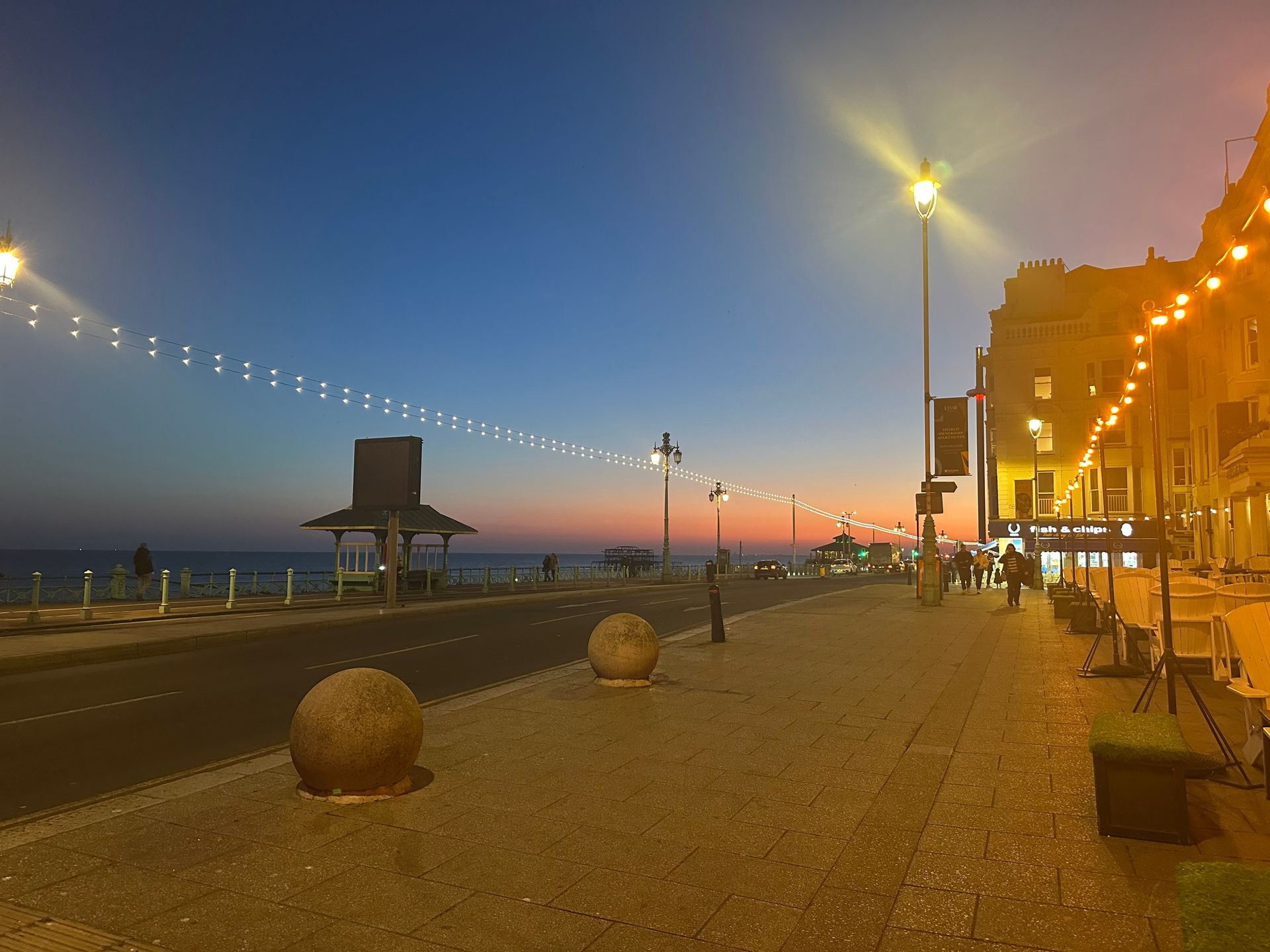 A city street at night with a sunset in the background.