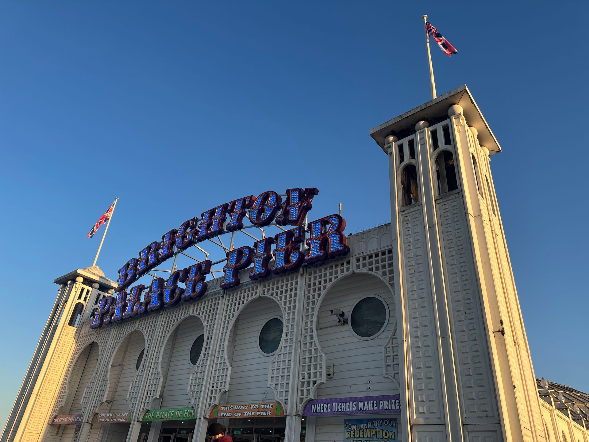 A large building with a blue sign that says brighton pier.