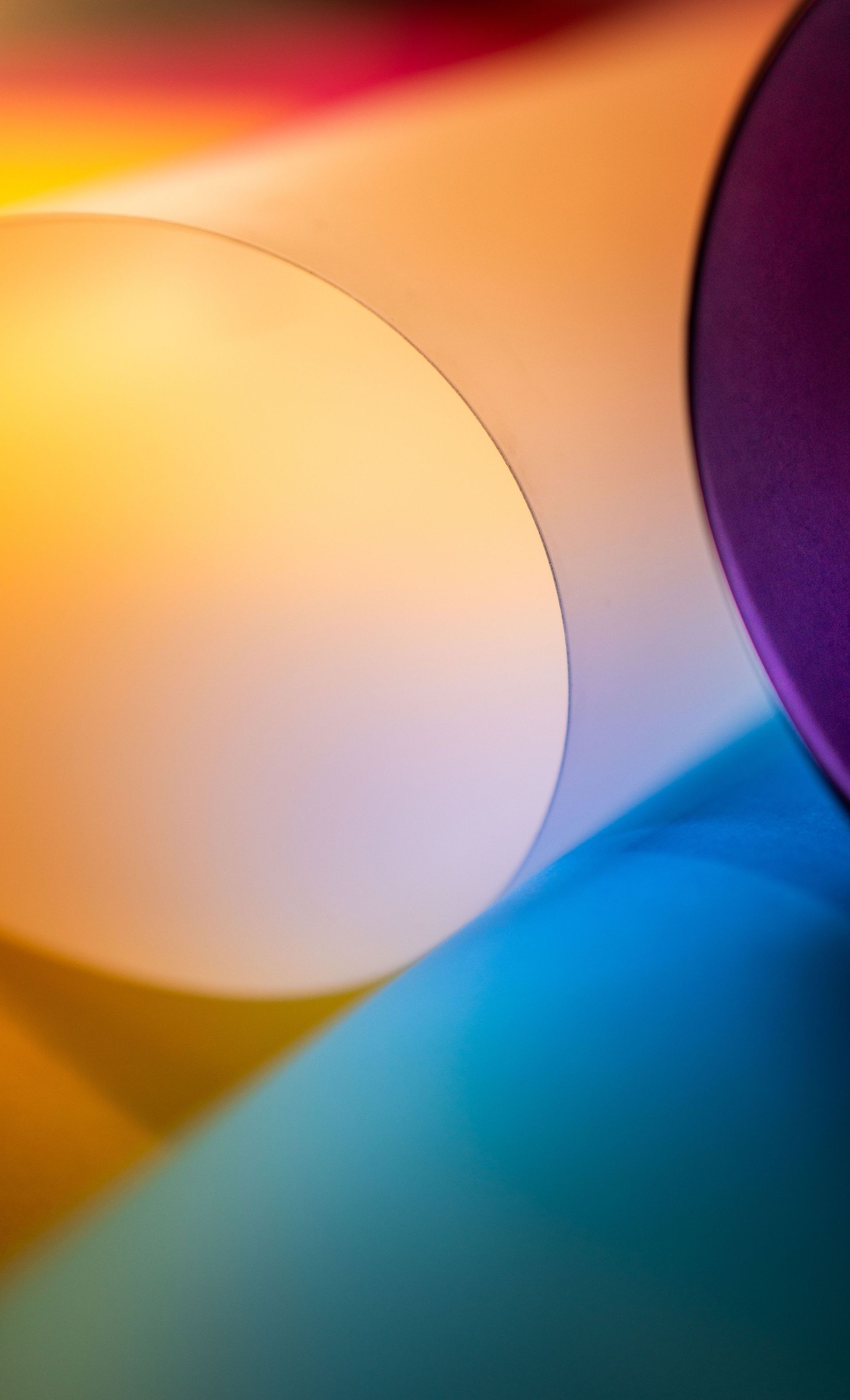 Abstract colorful background with overlapping translucent circles in yellow, orange, purple, and blue