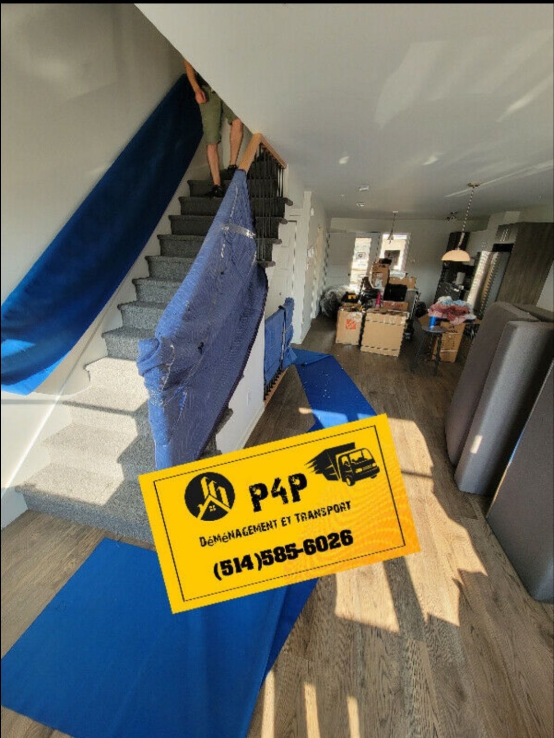 Une personne porte une couverture bleue dans un escalier.