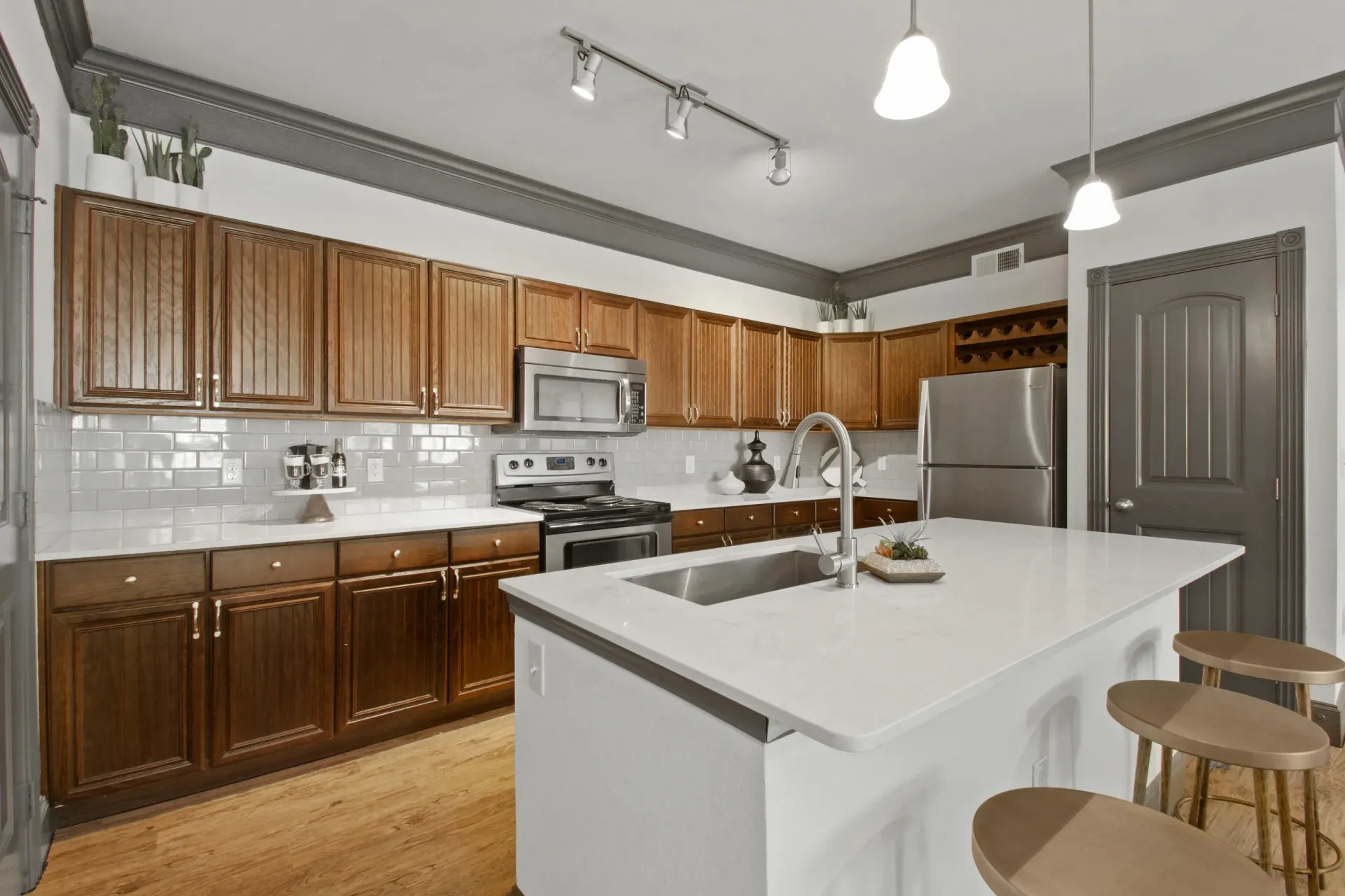 Kitchen with brown cabinets, white countertops, stainless steel appliances, and an island.