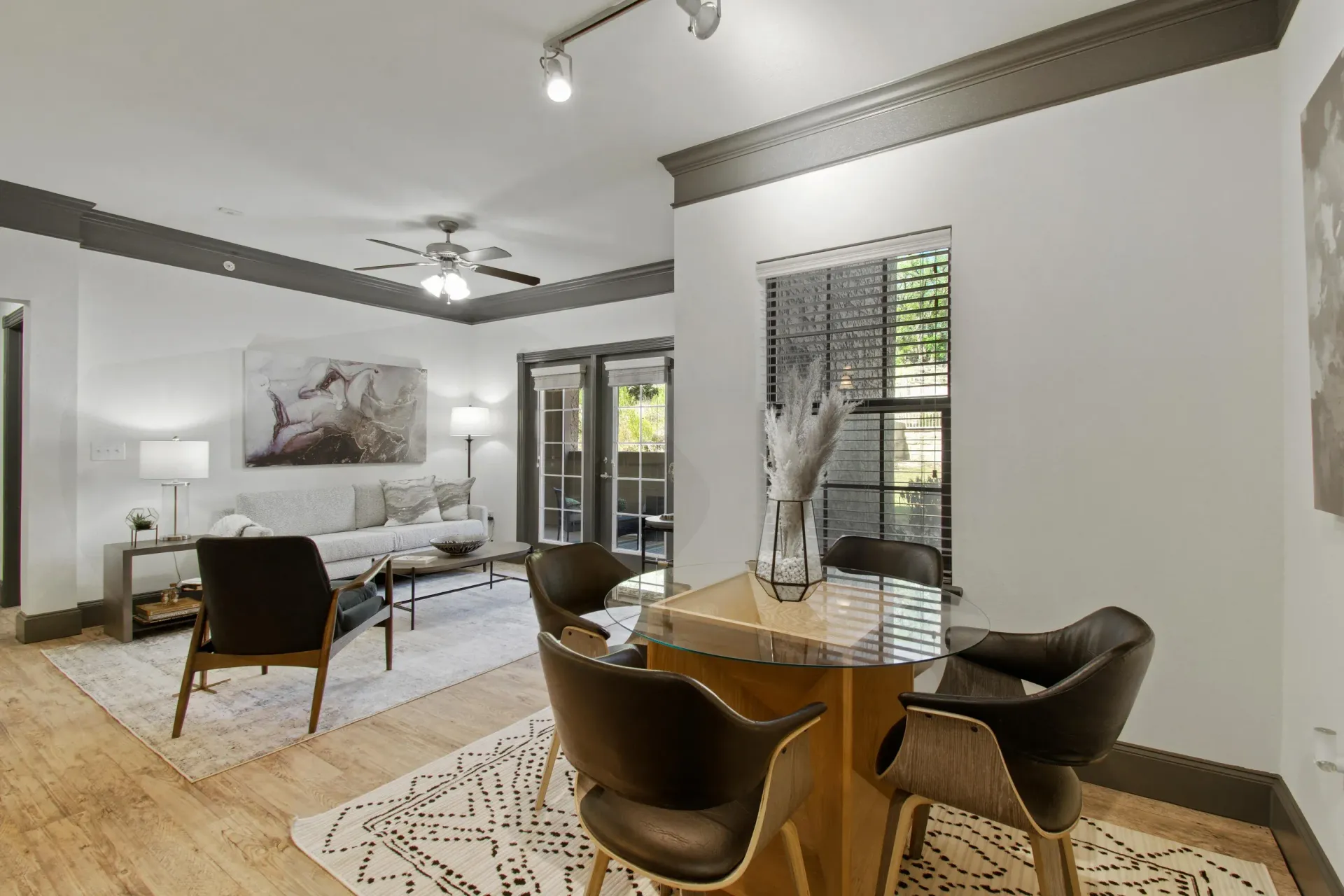 Open-concept apartment with a kitchen island, hardwood floors, and a living area with a balcony.