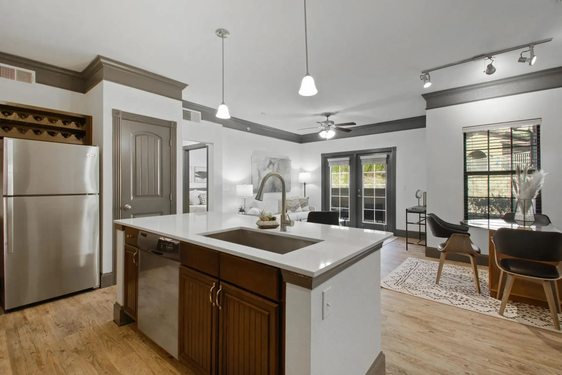 Kitchen with brown cabinets, stainless steel appliances, white countertop, and backsplash.