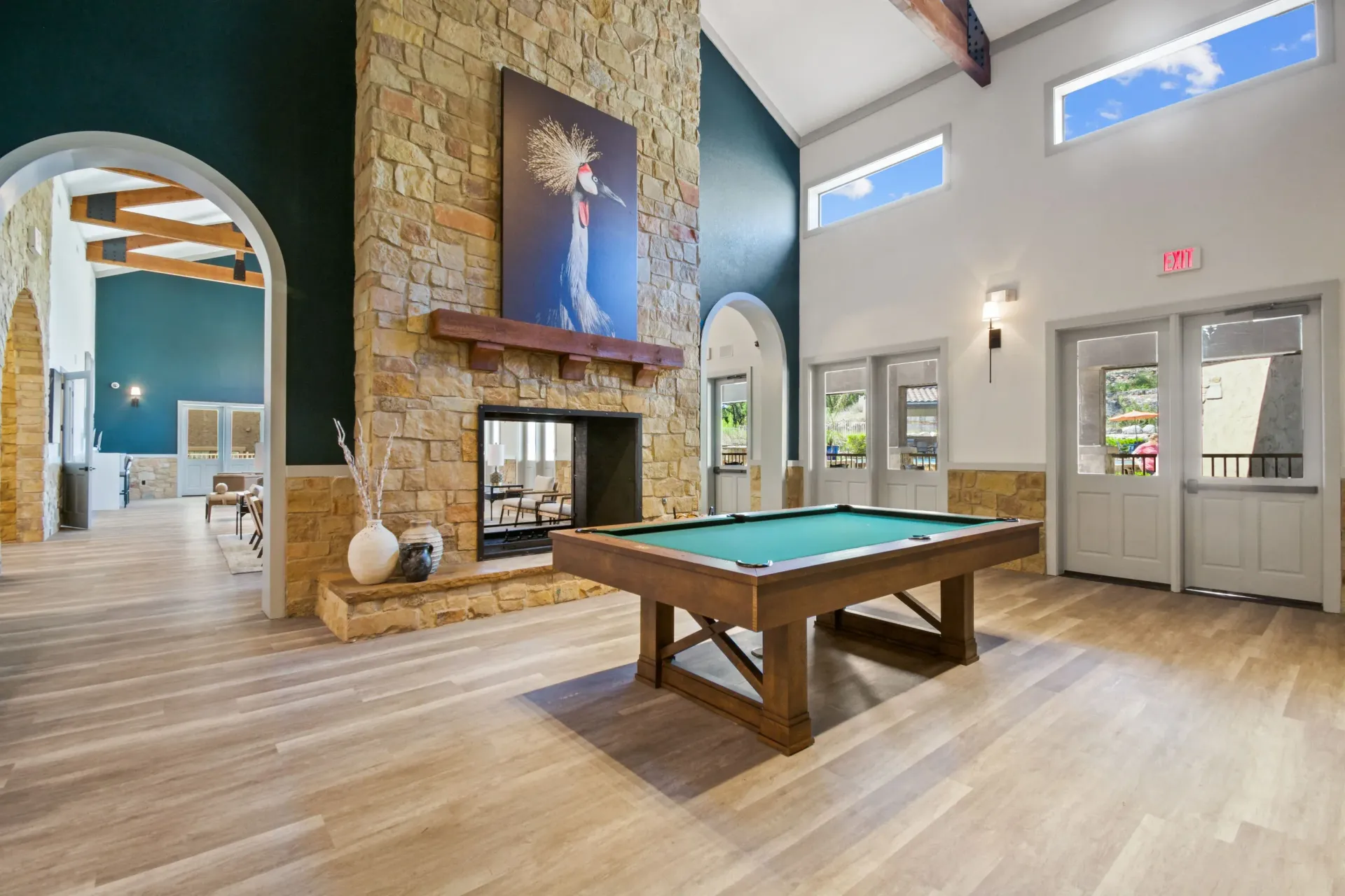 Courtyard with pool, tan buildings, blue sky, lounge chairs, and decorative landscaping.