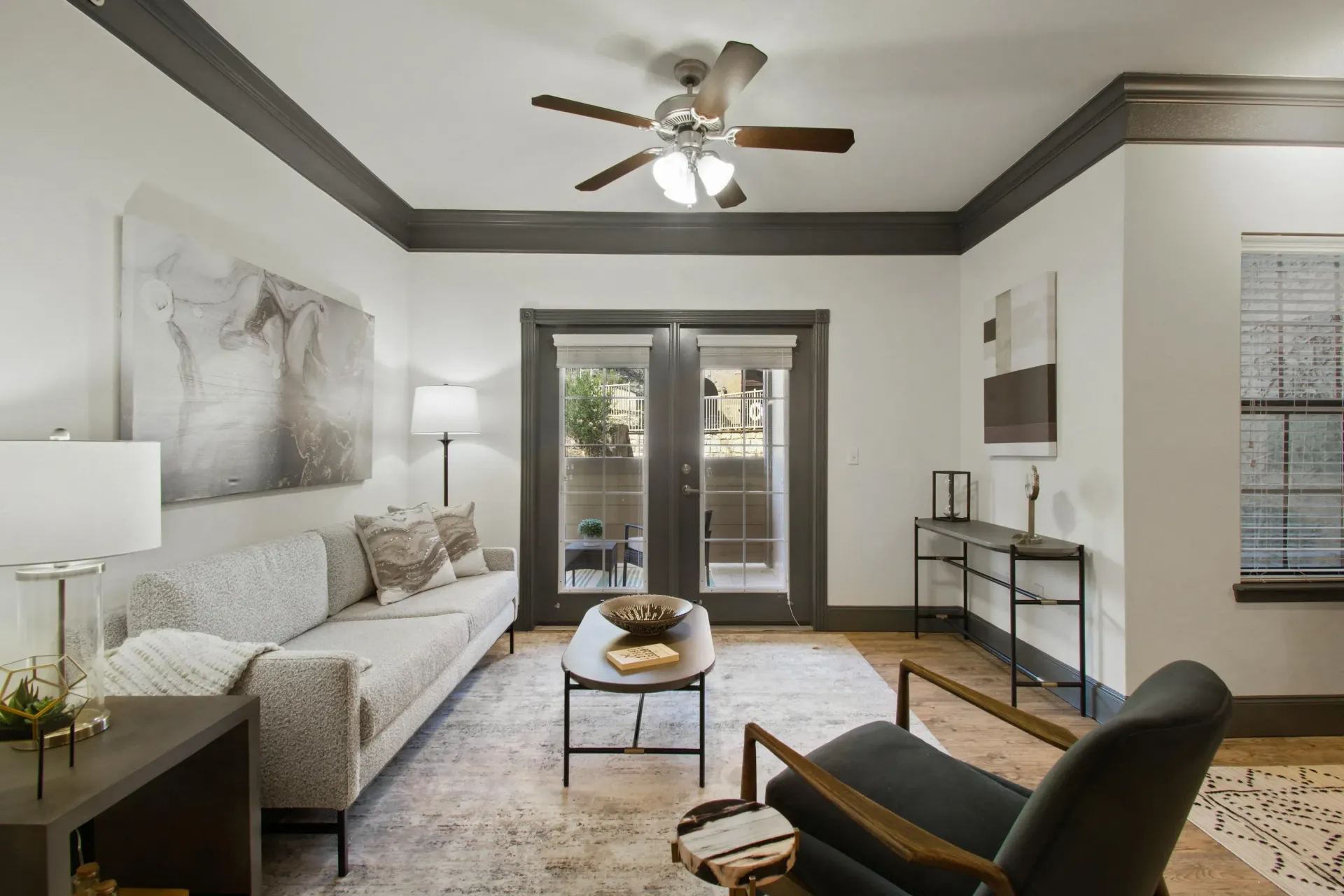 Lobby with sofa, chair, coffee table, and French doors, gray and neutral tones.