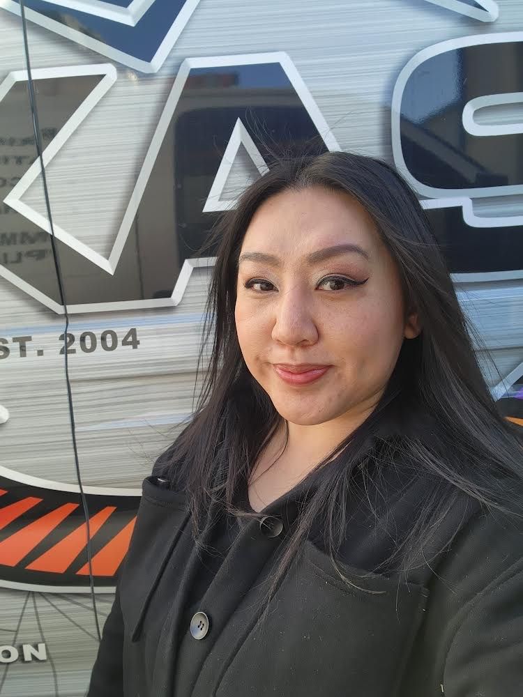 A woman is taking a selfie in front of a truck.