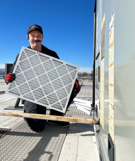 A man is holding a filter in front of a building
