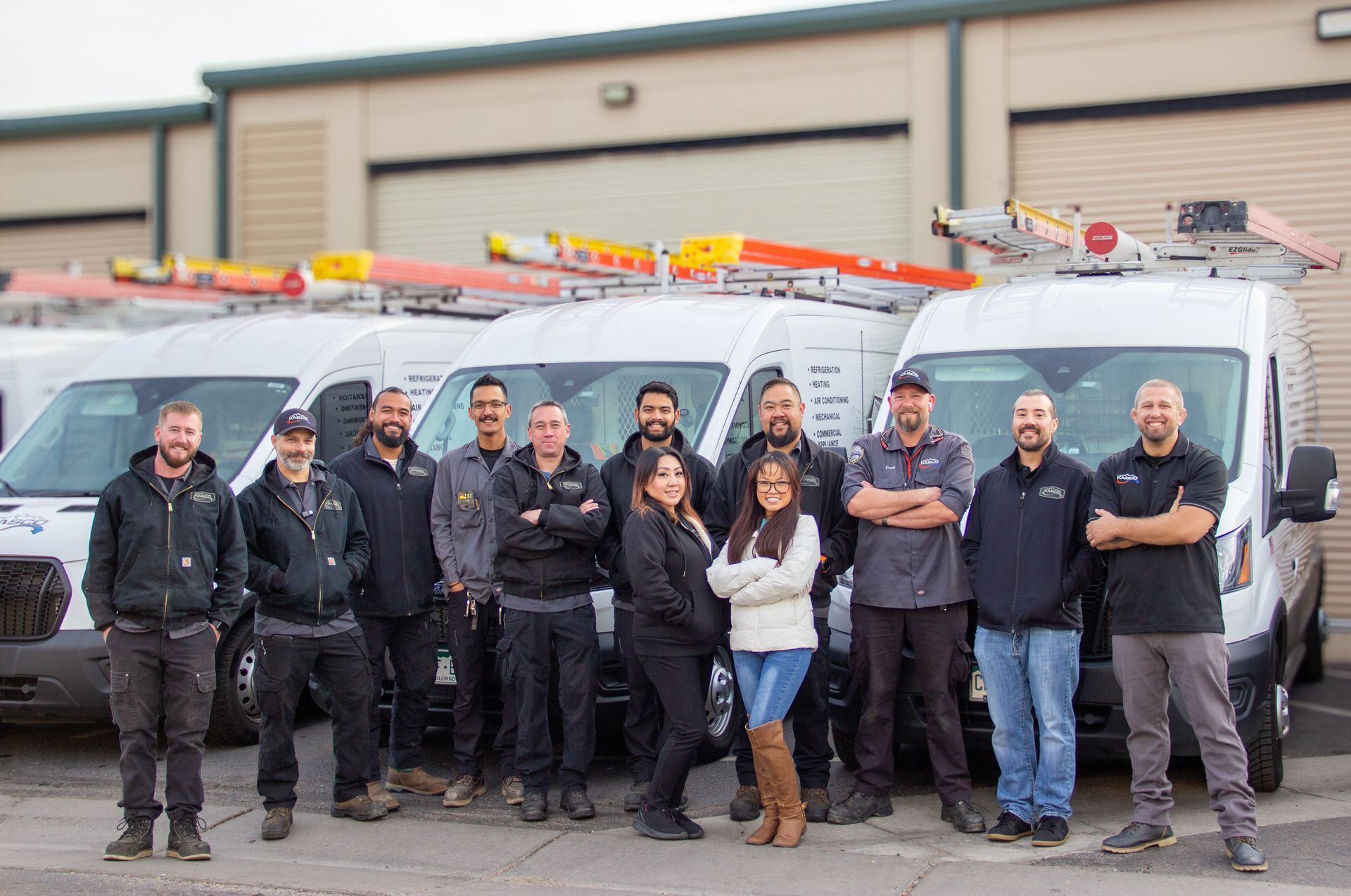 A group of people are posing for a picture in front of a van.