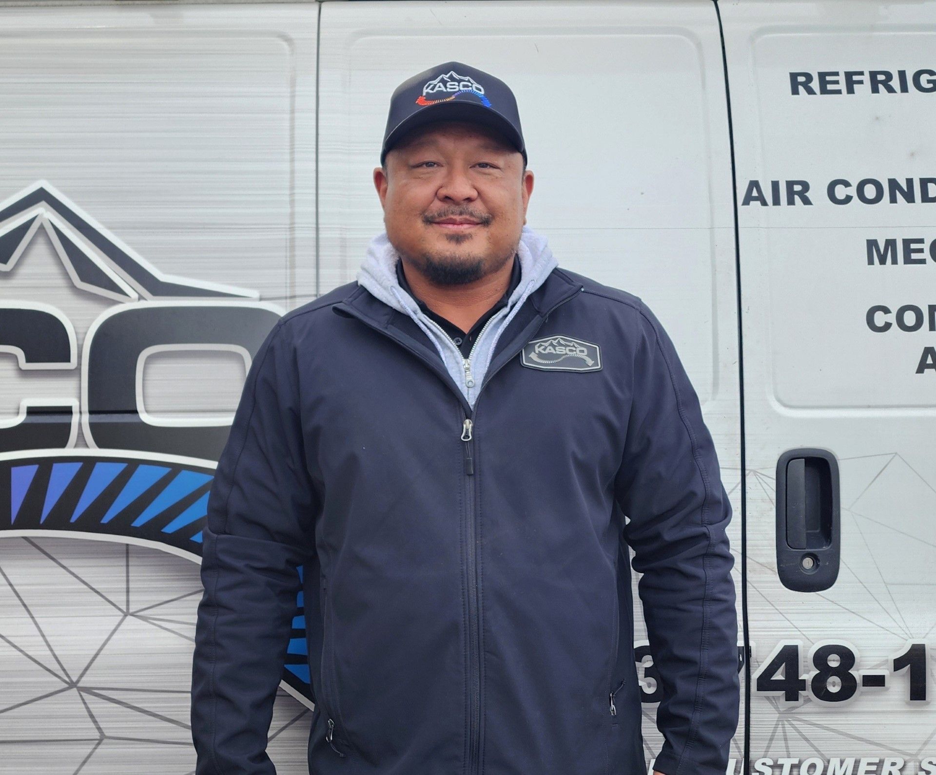 A man is standing in front of a van with the number 48-1 on it