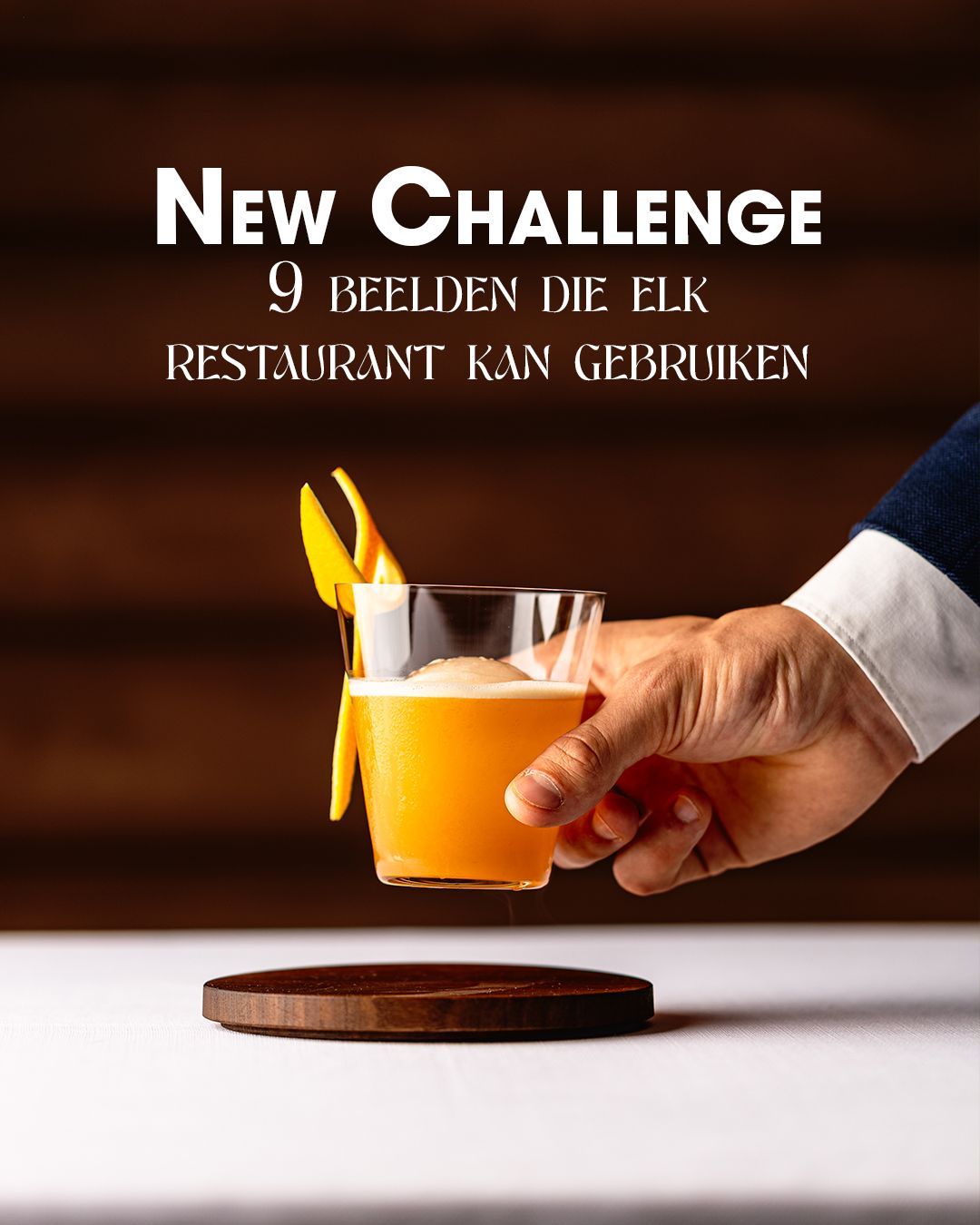 Hand die een oranje cocktail vasthoudt boven een houten onderzetter; de tekst luidt: “New Challenge”