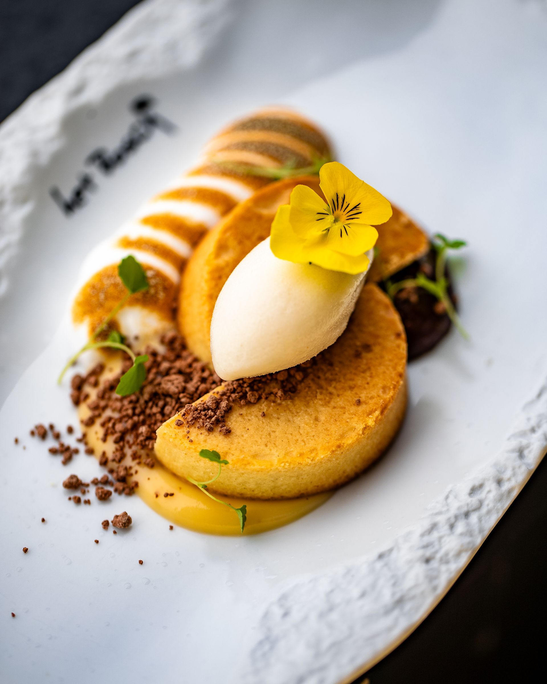 Een close-up van een bord met eten met een gele bloem erop