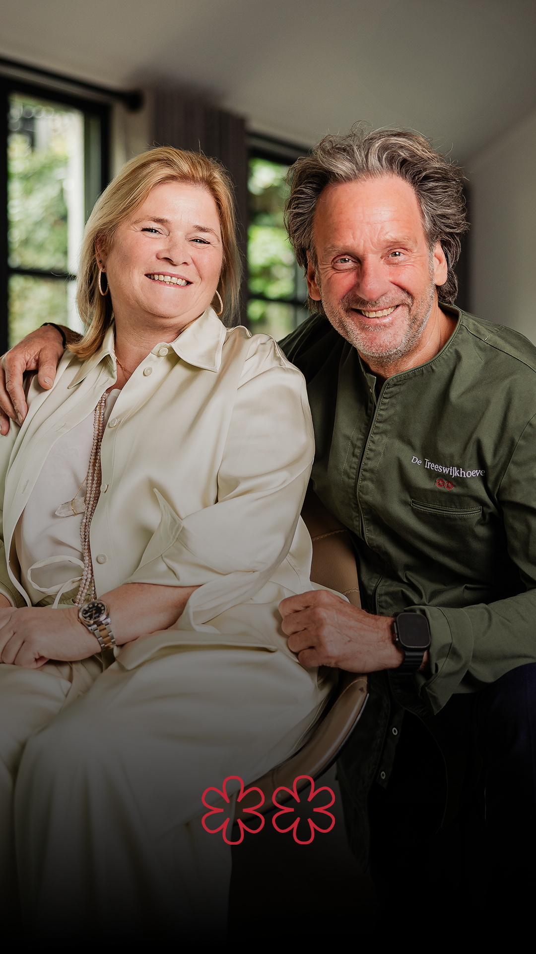 Een man zit buiten aan een glas wijn, draagt ​​een zonnebril en een pet. Op een oranje kussen staat 