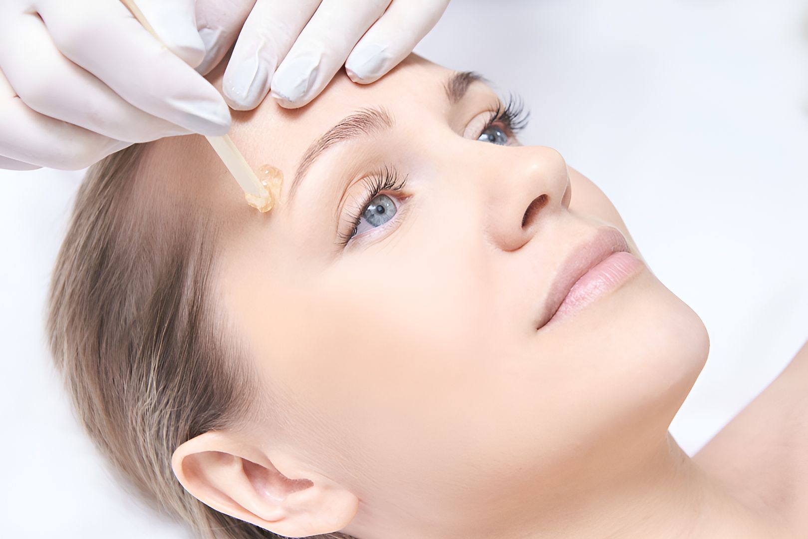 A Woman Is Getting Her Eyebrows Waxed In A Beauty Salon — Chez Belle Skin Care & Beauty Centre in Pimlico, QLD