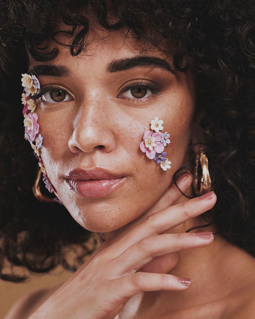 A Woman With Flowers On Her Face And Hoop Earrings — Chez Belle Skin Care & Beauty Centre in Pimlico, QLD