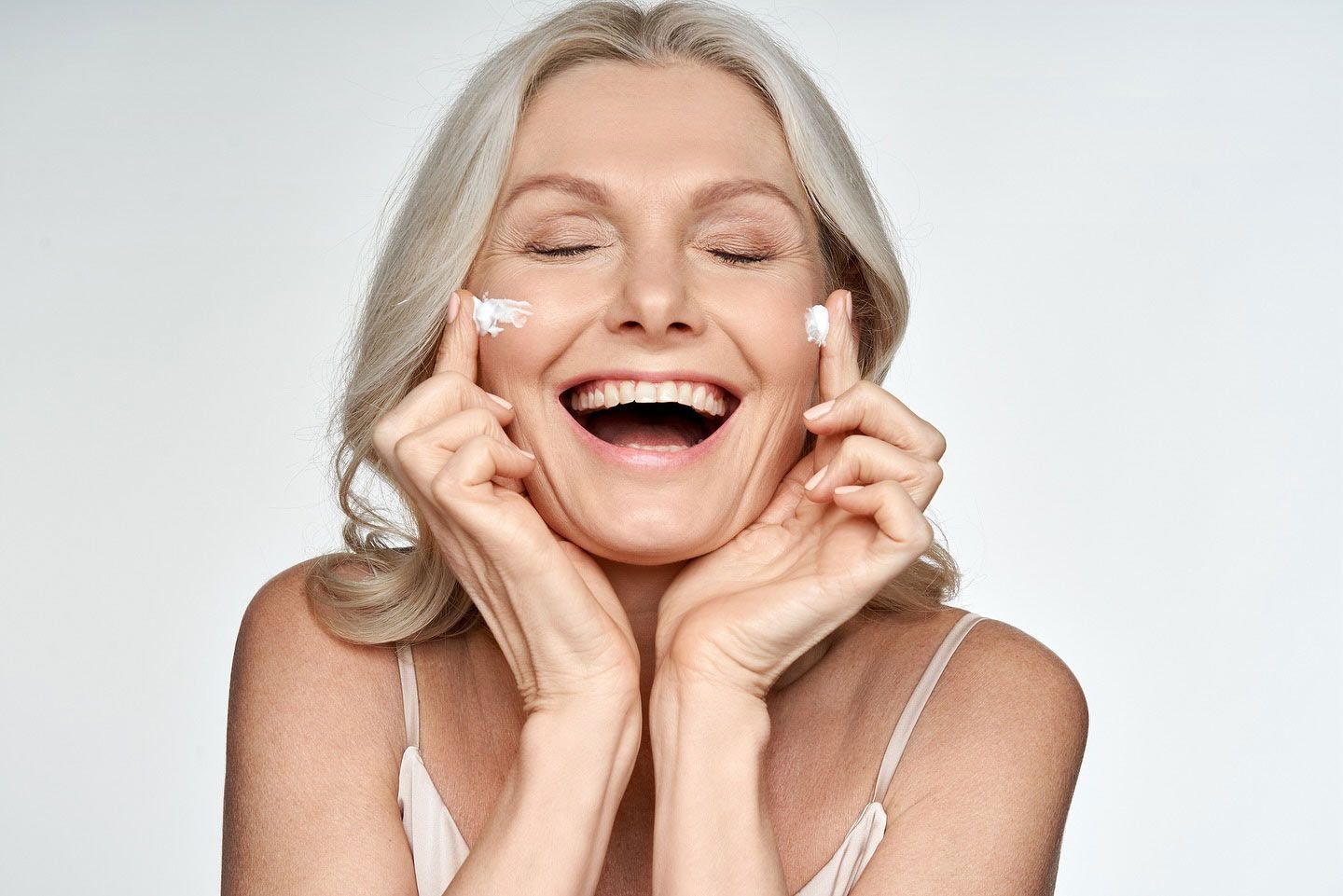 A Woman In A White Dress Is Sitting Down With Her Hand On Her Face — Chez Belle Skin Care & Beauty Centre in Pimlico, QLD