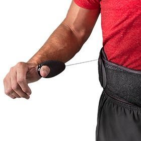Person using a black wrist exerciser on a forearm with a red shirt and dark waistband
