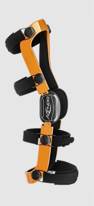 Orange-and-black hinged knee brace with adjustable straps and pads on white background