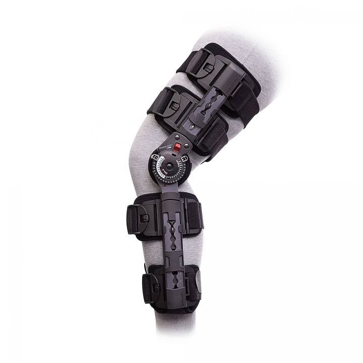 Black hinged knee brace with adjustable straps and a circular dial, isolated on white background