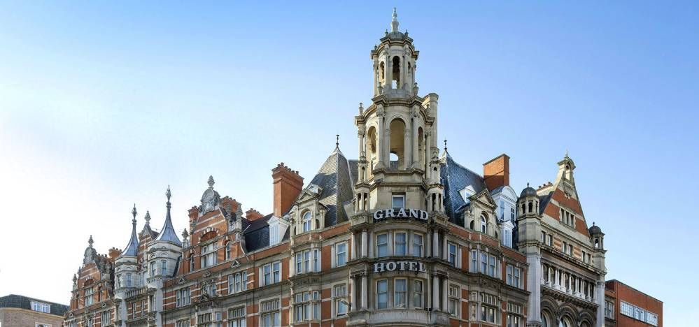 Ornate building facade with a central tower under a blue sky.
