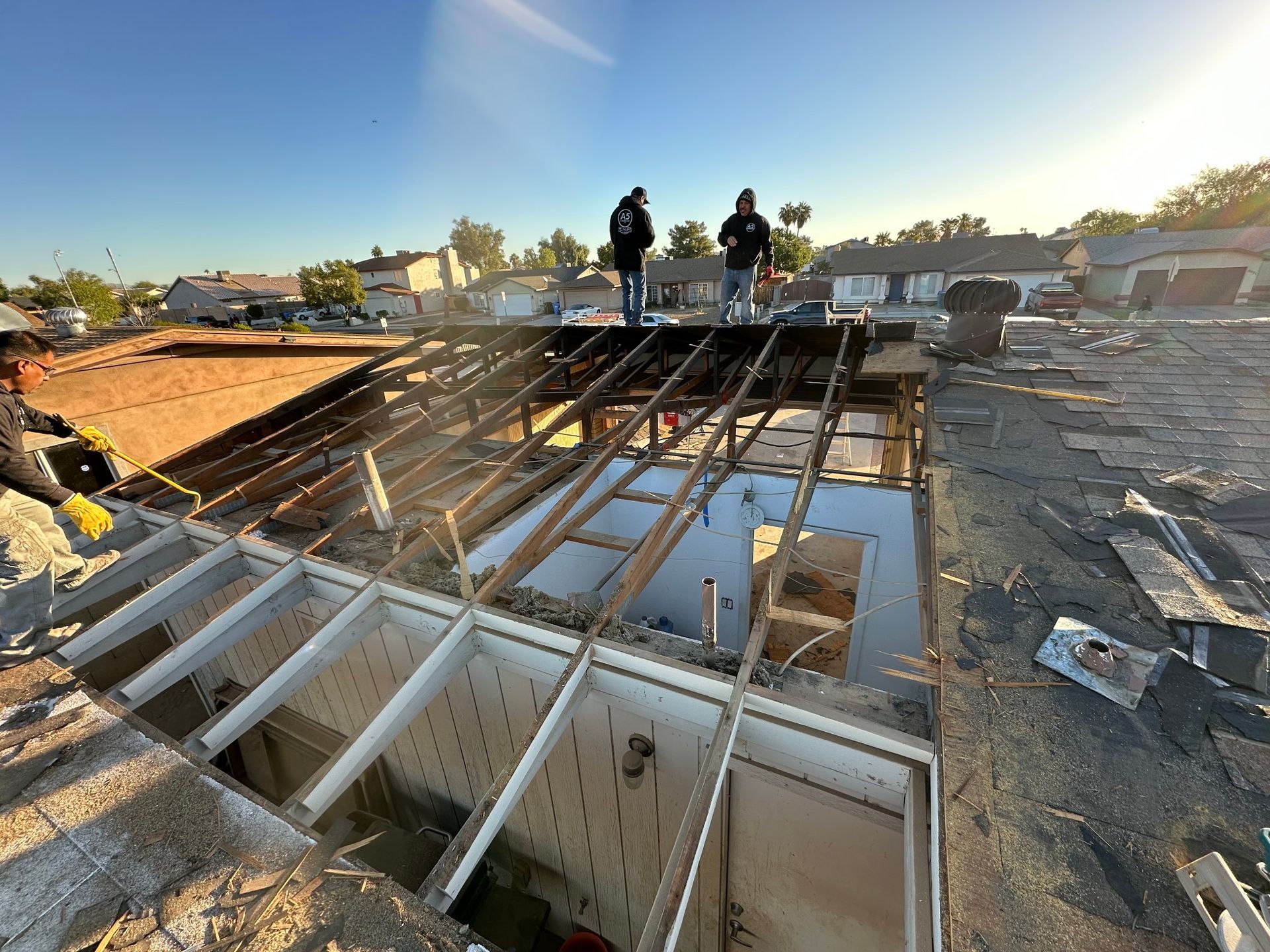 A couple of people standing on top of a roof.