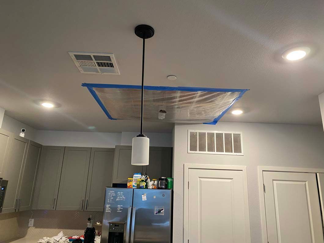 A kitchen with a light hanging from the ceiling.