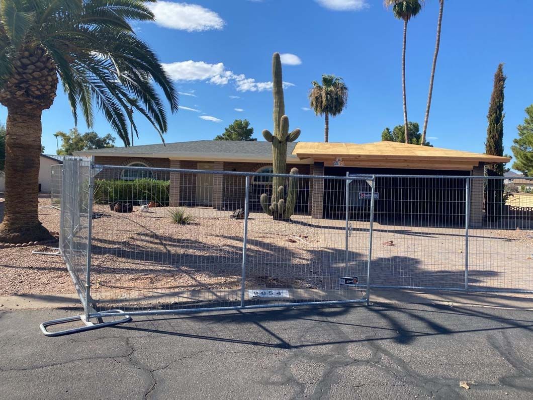 A house with a fence around it and palm trees in the background