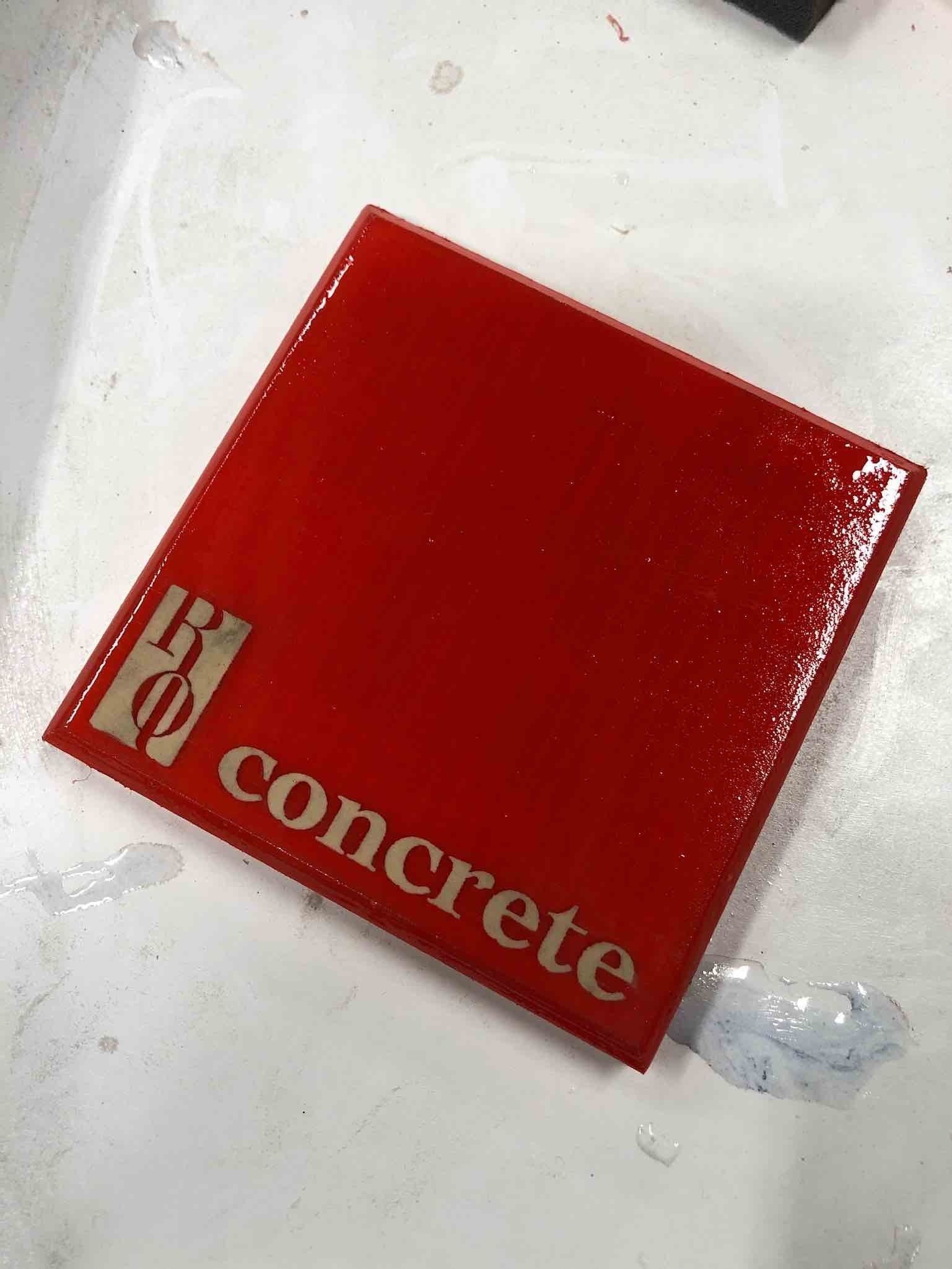 a red concrete sample square with the word RQ concrete on it