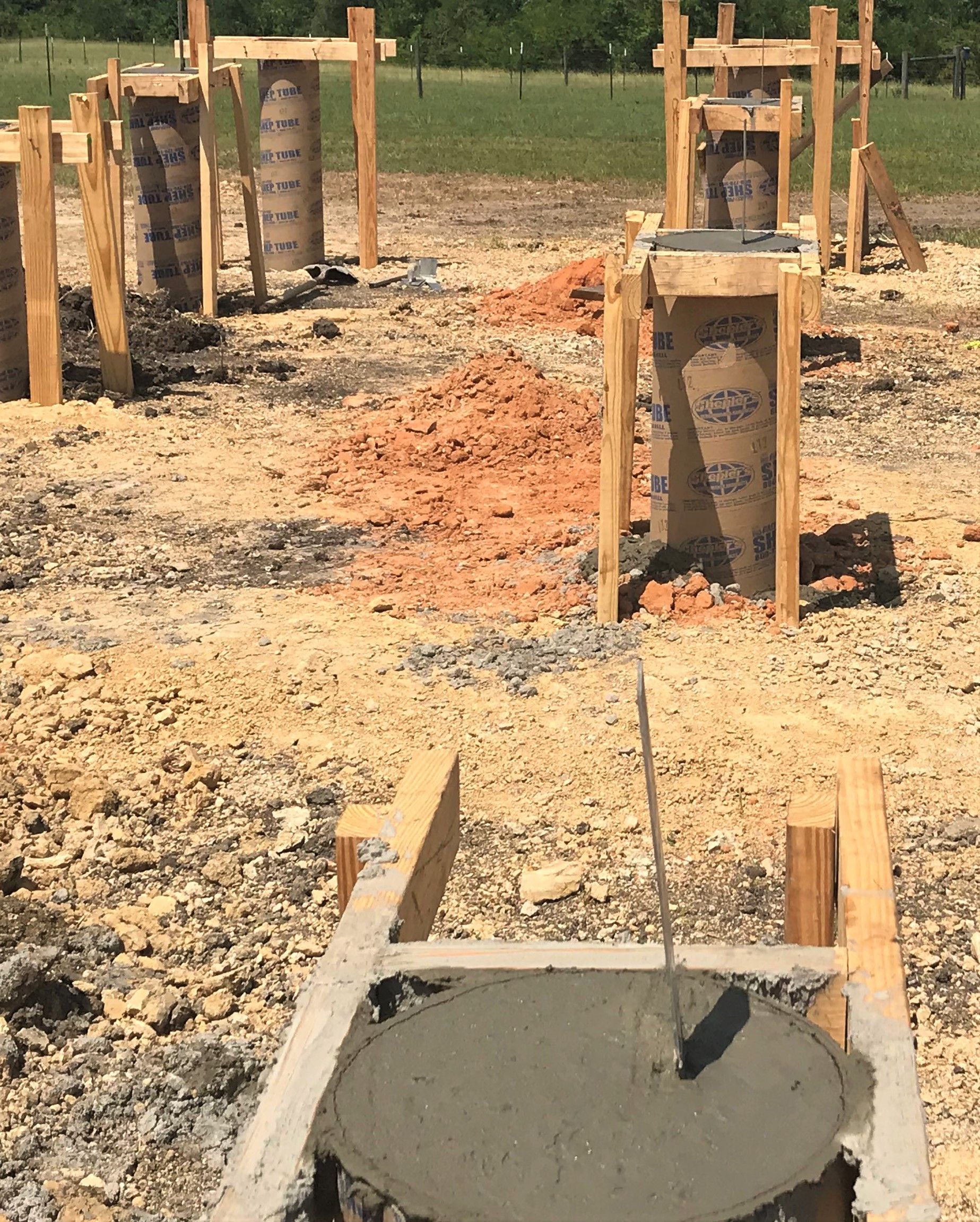 Foundation forms being filled with concrete at a construction site.
