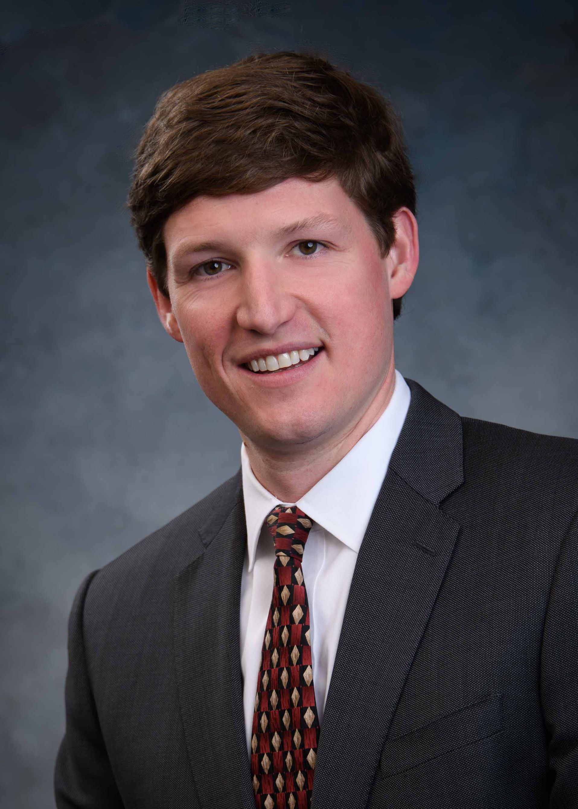 A man in a suit and tie is smiling for the camera.