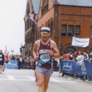 A man running a marathon with the number 20869 on his shirt