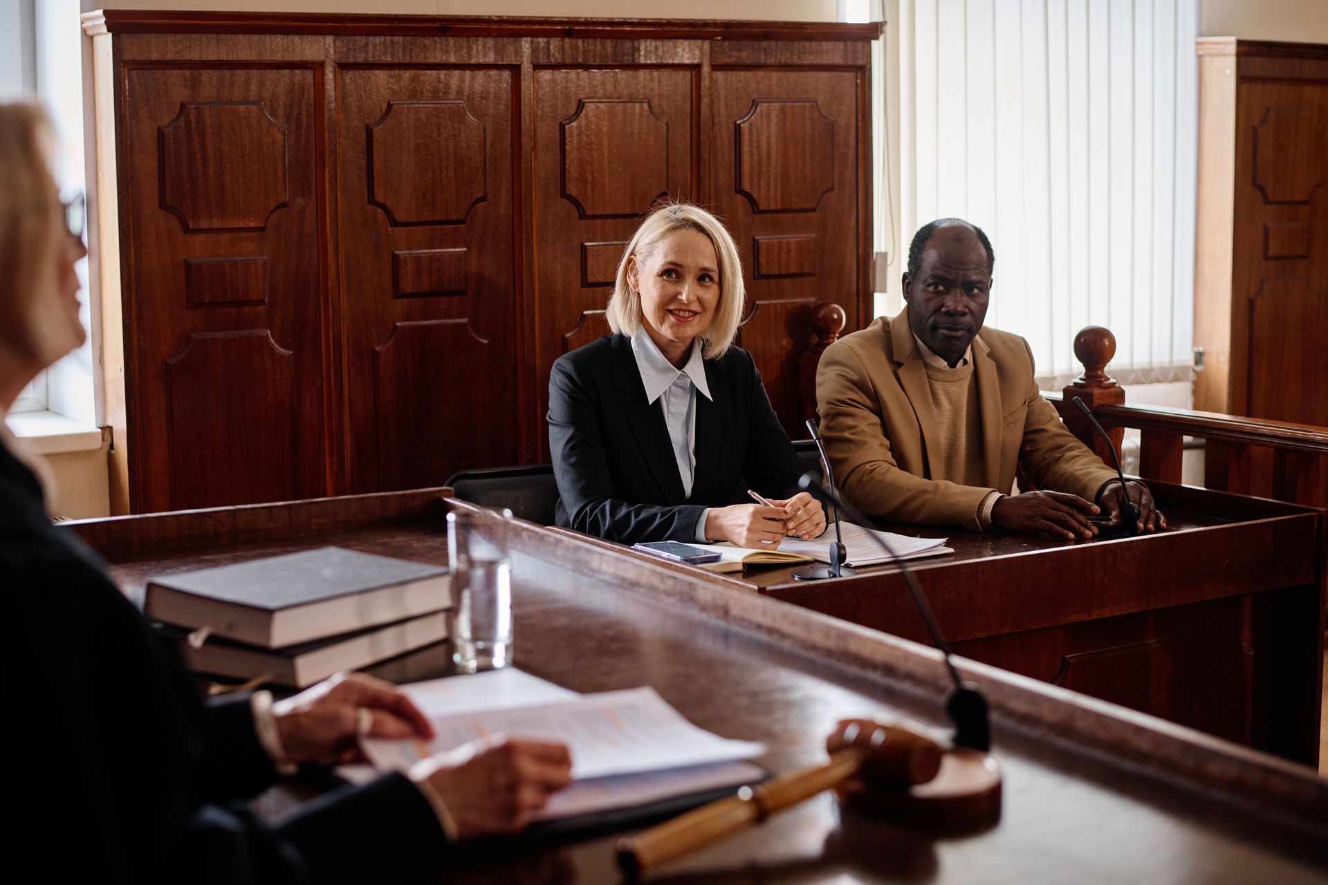A man and a woman are sitting at a table in a courtroom.