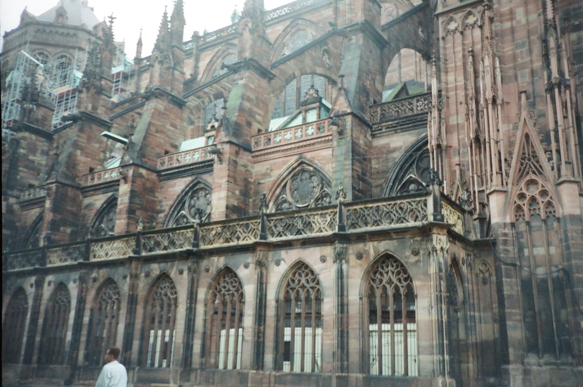 A man is standing in front of a large building