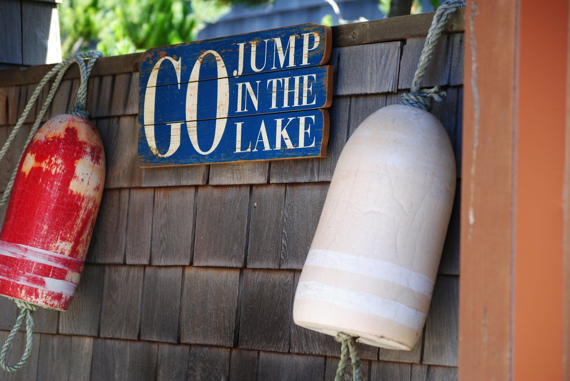 A sign that says jump in the lake on it